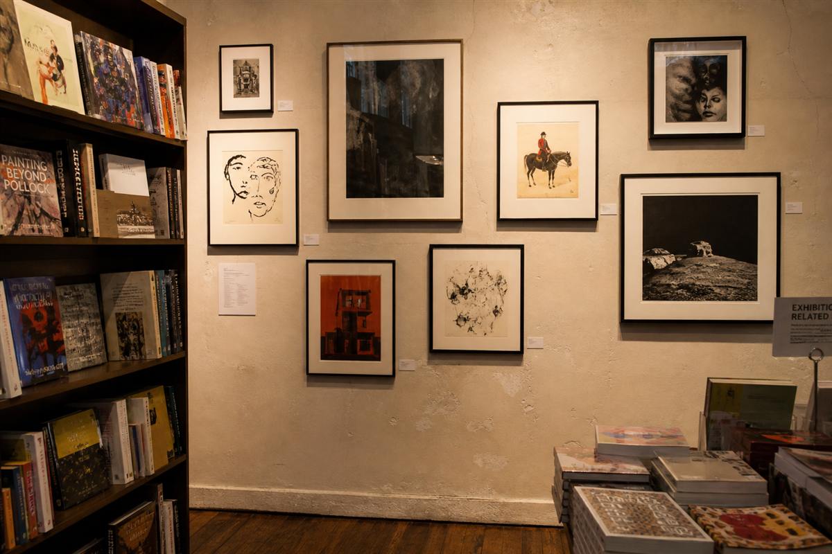 Framed drawings and art books on a studio wall